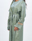 Abaya vert olive avec cape, manches ornées d'incrustations dorées et nœud à la taille.