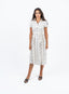 Robe bleu marine à pois blanche avec nœud à la taille.
