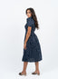 Robe bleu marine à pois blanche avec nœud à la taille.