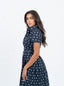 Robe bleu marine à pois blanche avec nœud à la taille.