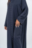 Abaya bleu marine avec incrustations au col.