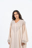 Abaya beige clair avec broderie décorative sur le col, les manches et le devant.